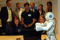 Premiere im Lernlabor: Maja und Isabell programmieren unter Anleitung von Kursleiter Daniel Blume den  Roboter Nao. Im Hintergrund Michael Uhlich von der Bezirksregierung Detmold, Bürgermeister Delfef Helling, Prof. Dr. Jochen Steil und Dr. Carola Haumann (CoR-Lab).  