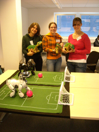 Die Roboter in der Technischen Fakultät begeisterten im vergangenen Jahr die Schülerinnen (v.l.): Sara Biller, Sabrina Möllmann und Anjuli Meier mit Roboterdinosaurier „Pleo“; im Vordergrund Roboterhund „Aibo“.