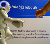 Roboter NAO aus dem teutolab-robotik der Universität Bielefeld kann sehen, hören, sprechen, tasten und kommunizieren – oder wie hier Schnick schnack schnuck spielen.
