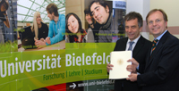 Staatsekretär Thomas Rachel (rechts) übergab den Bewilligungsbescheid an Rektor Professor Dr.-Ing. Gerhard Sagerer
