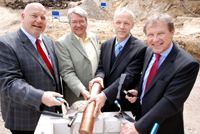 Heinrich Micus, Prof. Dr. Andreas Hütten, Dr. Martin Chaumet und Hans-Jürgen Simm (v.l.) versenken die Kapsel mit der Urkunde im Grundstein. 