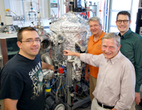 Mit einer „Sputter-Anlage“ stellen (v.l.) Dr. Timo Kuschel, Prof. Dr. Andreas Hütten, Prof. Dr. Günter Reiss und Dr. Andy Thomas ihre Nano-Magnetschichten her. Das künftige Spinelektronik-Zentrum wird mit einer neuen, noch genaueren Sputter-Anlage ausgestattet. 