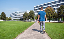 Bild: Student vor Gebäude X