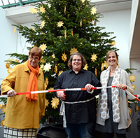 Bild: Startschuss für die Suche nach den Wünschen: Sarah aus der Tanzgruppe schneidet gemeinsam mit Johanna Will-Amstrong (l.) und Bettina Lang das Band durch. Foto: Universität Bielefeld