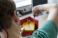 Bild: Der Vorgänger der Avikom-Brille kann zum Beispiel Beschäftigte in Werkstätten für Menschen mit Behinderung bei der Montage von Vogelhäuschen unterstützen. Foto: CITEC/Universität Bielefeld
