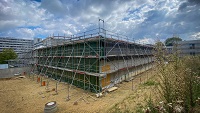 Das neue Hörsaalgebäude Y an der Konsequenz mit Blick auf das Universitätshauptgebäude. Die Montage der finalen Fassade wird für Oktober erwartet.