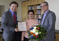 Bild: Universitätskanzler Hans-Jürgen Simm (links) und Bibliotheksdirektor Dr. Michael Höppner gratulieren der Jubilarin Henrike Thies