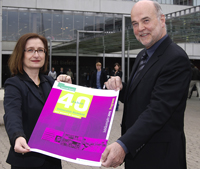 Bild: Prorektorin Joanna Pfaff-Czarnecka und Rektor Dieter Timmermann präsentieren das Plakat zum Universitätsjubiläum