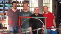 Bild: Sie erklären das Prinzip des Supraleiters anhand einer speziellen Modell-Schwebebahn (v.l.): TV-Moderator Adrian Pflug
